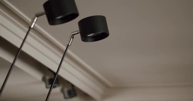 Bir çift modern siyah tavan lambası minimalist bir evin içine karşı. Çağdaş dekor ve ev ışıklandırması kavramları için ideal. Minimalist Ev Işığında Modern Siyah Tavan Lambaları