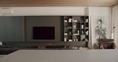 Televizyon, kanepe, kitaplık ve Samuray resimleriyle dolu modern oturma odası. Şık ve Minimalist Tasarım Rahatlatıcı bir atmosfer yaratır. Doğal Işık ve Tahta Tavan Sıcaklığı Arttırır. Ev Dekorasyonu