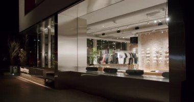 Geceleri bir pansiyon. Modern bir iç tasarımda gösterilen şık kıyafetler. Raflarda kaykaylar ve ayakkabılar. Şehir modası, perakende mağazası.