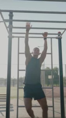 Odaklanmış sporcu, bir spor salonunda barfiks egzersizi yapıyor. Güç ve adanmışlık gösterisi yapıyor. Fitness, eğitim ve egzersizle ilgili kavramlar için mükemmel. Barfiks Çeken Atletik Adam