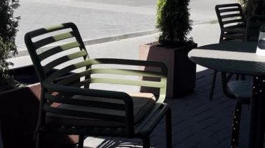 Güneşli bir yaz gününde boş kafeterya masası ve sandalyeler. Müşteri bekliyorum. Modern açık hava mobilyası. Sıcak bir atmosfer. Şehir manzarası. Sokak kafesi. Pavement Kafe 'de. Kaldırımlı kafe.