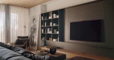 Televizyon, raflar, rahat kanepe ve şık dekorlarla modern oturma odası. Oda doğal ışıkla dolu ve rahat bir atmosferi var. Rahatlamak ve eğlenmek için mükemmel..