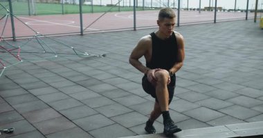 Spor sahasında atletizm eğitimi alıyor ve yan hamleler yapıyor. Formda kalmak için günlük egzersiz. Fitness Spor Sokağı Antrenmanı. Halka açık spor salonunda kas yap. Güç, motivasyon. Açık hava spor salonu.