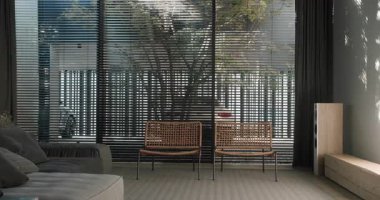 Modern mobilyaların ve büyük pencerelerden süzülen geniş doğal ışığın olduğu şık bir oturma odası. Doğal Işık ve Şık Dekorlu Modern Oturma Odası