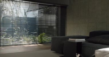 Çağdaş minimalist yatak odasında beton bir duvar, siyah yatak ve katmanlı pencere perdeleri var. Odanın genel olarak düzgün ve şık bir atmosferi var ve doğal ışık süzgeçten geçiyor..