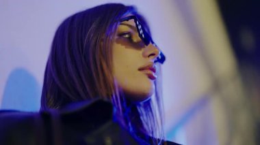 Yeraltı otoparkında poz veren uzun saçlı genç bir kadın model. Modern bir kadın. Profesyonel mankenin yüzü. Genç, lüks, seksi kadın. Dışarıdaki kameraya bakıyor..