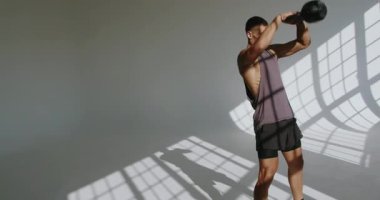 23 yaşında atletik fiziği olan bir adam dramatik gölge oyunuyla vurgulanan bir stüdyoda yoğun fiziksel antrenman yapıyor. Dramatik Işıklı Genç Atletizm Eğitimi Stüdyoda