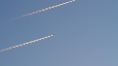 Arkalarında beyaz izler bırakarak açık mavi gökyüzünde üç uçak yükseklerde uçuyor. Yolcu uçakları varış yerlerine, iş seyahatlerine ya da tatile gidiyorlar.