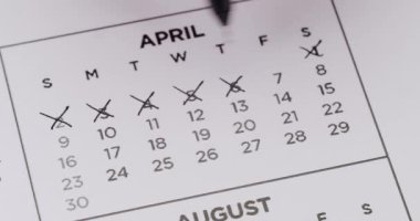 Nisan ayında önemli bir tarihi işaretleyen, planlama ve zamanlamayı sembolize eden, üzeri çizilmiş tarihleri olan bir takvimin yakın plan resmi. Nisan 'da Kalem İşaretleme Önemli Tarihli Takvimin Kapanışı