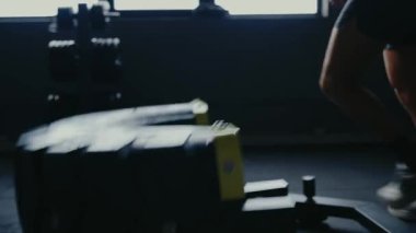 Spor salonunda çalışıp güç ve dayanıklılık kazanmak için lastik çevirme egzersizi yapan bir adam. Adam Güç Eğitimi için Spor Salonu 'nda Tekerlek Döndürme Egzersizi yapıyor. Spor Salonunda Ağır Lastik Kaldıran Adam