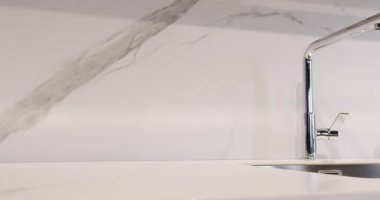 Yemek odasında zarif ve rahat bir ev var. Modern lavabosu olan yerli mutfak. Minimalist yemek masası olan modern mutfak odası. Modern Minimalist Evi. Modern gri ve beyaz mutfak mobilyaları.