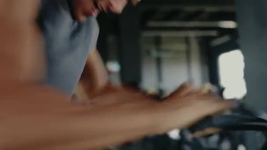 Spor salonunun içinde bisiklete binen birinin odaklanmış görüntüsü. Fitness, egzersiz motivasyonu ve sağlık yaşam tarzı kavramı. Jimnastik Ortamında Sabit Bisiklet Egzersizi