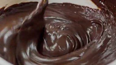 Çikolotalı ganache 'ye yakın plan, pürüzsüz ve parlak dokusunu gözler önüne seriyor. Aşçılar ve tatlı aşçıları için mükemmel. Parlak Çikolatalı Ganache Hareketi, Tatlı Tarifleri İçin İdeal