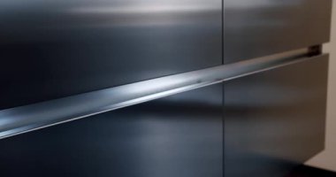 Minimalist yemek masası olan modern mutfak odası. Modern Minimalist Evi. Modern gri ve beyaz mutfak mobilyaları. Yemek odasında zarif ve rahat bir ev var. Modern lavabolu Ev Mutfağı.