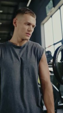 Spor salonunda göğüs presi makinesiyle çalışan atletik bir adam. Odaklanmış ve kararlı. Spor salonunda Göğüs Baskısı Makinesi 'ne odaklanmış bir adam. Spor salonunda Makine 'de egzersiz yapan adam. Dikey