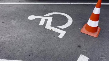 Trafik konisi olan boş engelli park yeri. Engelliler için ayrılmış park yeri. Engelliler için erişilebilirlik ve kapsayıcılık. Park yerinde trafik konisi..