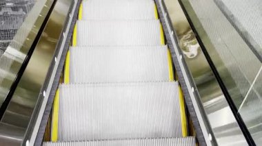 Modern binada boş yürüyen merdiven yükseliyor. Alışveriş merkezindeki hareket halindeki merdivenin yakın görüntüsü. Yürüyen merdivende pürüzsüz bir gezinti. Yürüyen merdivenlerin görüntüsü. Modern yürüyen merdiven sistemi.