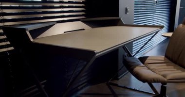 Rahat çalışma odasında minimalist deri koltuklu modern ahşap çalışma masası. Oda palmiyesi dekoru. Minimalist siyah panjurlar. Beauty Interior 'da yatak odası aksesuarı, deri koltuk ve modern masa..