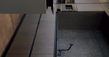 Modern ve geniş ahşap mutfak odası. Gayrimenkul. Bir adası olan lüks bir mutfak. Lüks evde modern iç mekan. Modern Krom Musluk. Yeni Ev 'de minimalist tasarım. Dikey video.