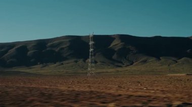 Uçsuz bucaksız, kurak Fas çöl arazisinde ilerliyoruz. Ufuk çizgisine doğru uzanan tek bir güç hattı dalgalanan tepelere karşı katıksız bir tezat oluşturuyor. Fas 'ın uzak bölgelerinin güzelliği.