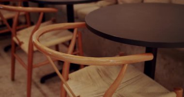 Ahşap sandalyeli, tekstil malzemeli ve siyah masalı modern minimalist kafe. Ahşap sandalye ve masayı kapat. Eco Friendly Cafe. Kafede modern ahşap kumaş sandalye ve masa mobilyası..