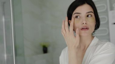 Banyoda kadın göz bandı uyguluyor, güzellik ve güzellik için günlük cilt bakımını yapıyor. Cilt Rutini İçin Banyo 'da Göz Bandı Kullanan Kadın