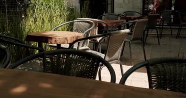 Sokaktaki kafede siyah modern Charis 'li ahşap masalar. Sokak kafesi. Modern Terrace. Boş restoran. Yaz sabahları boş bir kafe. Modern açık hava kafesi..