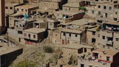 Atlas Dağları 'ndaki geleneksel Fas köyü. Evler kerpiç ve betondan inşa edilmiştir. Giysiler güneşte çatılarda kuruyor. Berber köyünde günlük yaşam.
