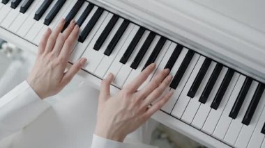 Piyano çalan ellerin yakın çekimi, dingin bir ortamda müzik yeteneği ve zarafeti sergilemek. Müzik, yaratıcılık ve sanatçılık konuları için mükemmel. Eller Kapalı Piyano Çalarken