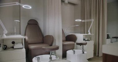 Konforlu sandalyeleri, parlak ışıkları ve gösterişli çalışma yerleriyle modern manikür salonu. Güzellik tedavileri için mükemmel donanımlı..