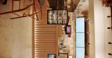 Ahşap sandalyeli, tekstil malzemeli ve siyah masalı modern minimalist kafe. Boş yemek kumaşı ve tahta sandalye. Kafedeki modern ahşap kumaş sandalye ve masa mobilyası. Dikey video