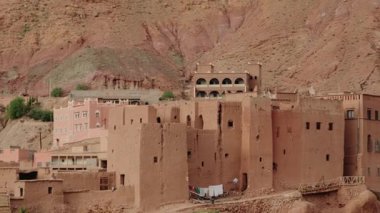 Atlas Dağları 'na karşı kurulmuş geleneksel Fas köyü. Kerpiç 'ten inşa edilen binalar manzaraya uyum sağlıyor. Bu sahne, tarih ve zamansızlık hissini uyandırıyor..
