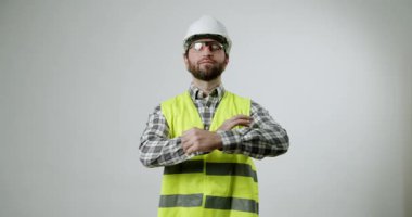 Kendine güvenen inşaat işçisi güvenlik gözlüklerini ayarlar ve kollarını çapraz yapar. Endüstriyel işlerde profesyonelliği ve güvenliği temsil ediyor. İnşaat, mühendislik veya işgücü ile ilgili projeler için ideal.