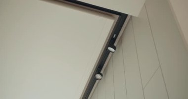 Sürgülü kapı sistemine yerleştirilmiş şık, siyah pist ışıklandırmalı, temiz, minimalist bir dekorun geliştirildiği modern bir ev tasarımı. Sürgülü Kapıdaki Modern İç Aydınlatma