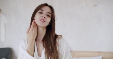 Mükemmel sağlıklı cilde sahip bir kadın elleriyle yüzüne dokunuyor ve cildinin pürüzsüz doğal cildinin tadını çıkarıyor. Yaşlanma karşıtı ciltler evde hazırlanıyor. Sağlıklı kuru cilt bakımı güzellik konsepti, cilt bakımı,