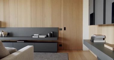 Ahşap duvarlı ve gri mobilyalı modern çağdaş. Gri kitaplıklı lüks Modern Ev İçi. Modern rafları ve kitabı olan minimalist bir iç mekan. Ahşap modern kapısı olan lüks şık bir oda.