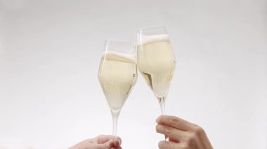 Two glasses of champagne on white isolated background, Cheers. new year celebration. Hands of happy friends cheering celebrating holidays with wine.say a toast, celebrate Christmas party with friends.