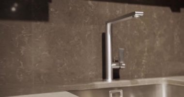 Minimalist gümüş musluğu olan modern mutfak odası. Modern minimalist ev. Modern gümüş lavabosu olan yerli mutfak. Minimalist modern mutfak odası. Mutfakta mermer duvarlı rahat bir ev.