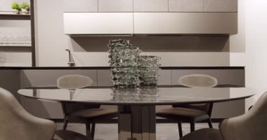 Deri, modern gri sandalye mutfak ve yemek masasında. Modern Minimalist Evi. Mermer masalı modern gri ve beyaz mutfak mobilyaları. Yemek odasında zarif ve rahat bir ev..