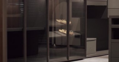 Black wardrobe with classic shirt , Luxury Bedroom With Walk In Closet. Dressing room with things. Elegant Wooden Built Walk In Closet Decoration. Luxury Dressing Room With Closet.