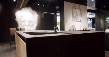 Modern ahşap mutfak mobilyaları. Zarif, rahat ve Minimalist Ev. Modern siyah lavabosu olan yerli mutfak. Minimalist yemek masası olan modern mutfak odası. Modern Minimalist Ev.