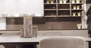 Mermer masalı modern gri ve beyaz mutfak mobilyaları. Yemek odasında zarif ve rahat bir ev var. Deri, modern gri sandalye mutfak ve yemek masasında. Modern Minimalist Ev.