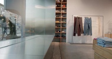 Modern ve minimalist giyim mağazalarının iç kısımları tarafsız tonlara ve doğal malzemelere odaklı. Mağazada büyük bir vitrin penceresi, ahşap raflar sergi kapakları, elbise rafları yer alıyor.