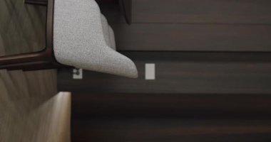 Koyu ahşap elementler ve temiz, düz bir tasarım içeren minimalist bir ortamda modern gri kumaştan bir yemek sandalyesinin yakın çekimi. Modern Gri Kumaş Yemek Sandalyesi. Dikey
