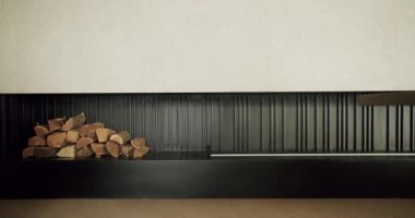 Minimalist iç mekan, yumuşak beyaz tavanın altındaki şık siyah bir duvara düzgünce dizilmiş bir odun yığını içeriyor. Doğal ve modern tasarım elementleri arasındaki mükemmel denge.
