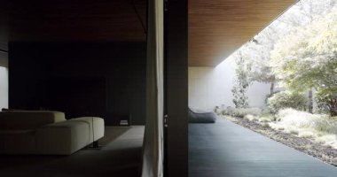 Modern oturma odası, sakin bir açık hava bahçesine kusursuz bir şekilde bağlanıyor. Tasarımda minimalist mobilyalar ve geniş cam pencereler yer alıyor. Modern Ev ve Dış Tasarım