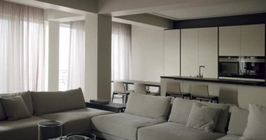 Modern bir mutfakla kusursuz bir şekilde harmanlanan çağdaş tasarım salonu, minimalist mobilyalar ve nötr tonlar içeriyor. Entegre Mutfak Alanlı Zarif Modern Oturma Odası