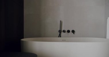 Zarif, minimalist bir banyo. Parlak, beyaz, serbest bir küvet ve modern eşyalar. Basitlik ve lüks yayıyor. Serbest Küvet ve Çağdaş Eşyalar ile Modern Minimalist Banyo