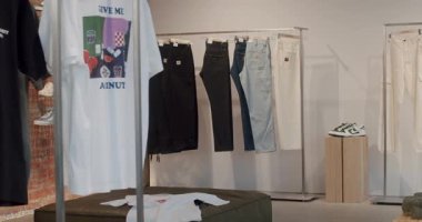 Modern bir mağazada çeşitli moda pantolon ve gömleklerle raflar. Dükkânda ahşap mobilyalar ve açık tuğla bulunuyor. Chisinau, Moldova - 18 Ocak 2025