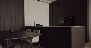Pürüzsüz ve modern mutfak iç mimarisi koyu ahşap mobilyalar, zarif tasarım ve temiz çizgiler. Çağdaş yaşam alanları ve şık ev ortamları için ideal. Minimalist Mutfak